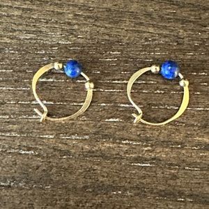 Gold tone earring with blue and gold beads.